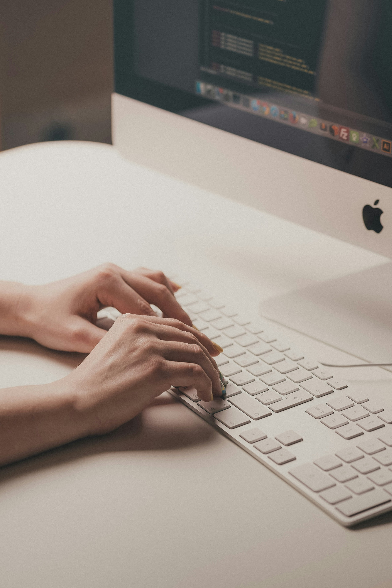 Person typing at a desktop computer.